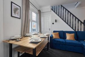 a dining room with a table and a blue couch at Cosy 3-Bedroom House in Seaham - Street Parking in Seaham