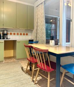cocina con mesa de madera y sillas rojas en Kaamos Old House, en Rovaniemi