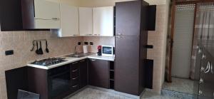 a small kitchen with a stove and a microwave at Mara casa vacanza in Maracalagonis