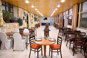 a restaurant with tables and chairs in a room at Jabal Dana Hotel - the highest hotel in Jordan in Dana