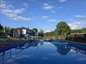 a swimming pool with a house and a blue sky at Drawa in Przesieki