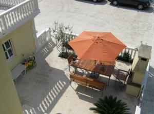 an orange umbrella sitting on top of a patio at Apartments Villa Novak in Slano +67 photos