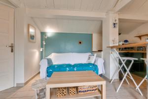 a living room with a blue couch and a table at 2km des plages- Bassin d'Arcachon- Cocon pour 2 in Lanton +8 photos