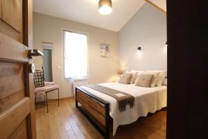 a bedroom with a bed with white sheets and a window at Chez fontaine in Lahonce