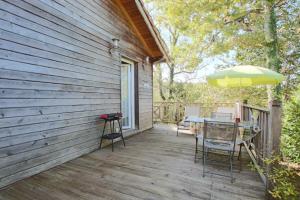 a wooden deck with a table and an umbrella at Chez fontaine in Lahonce +8 photos