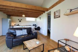 a living room with a leather couch and a table at Chez fontaine in Lahonce