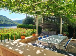 a table and chairs on a patio with flowers at Apartment Ana Broce in Broce