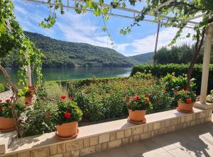 a garden with flowers and a view of a lake at Apartment Ana Broce in Broce