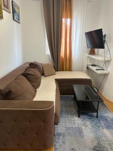 a bedroom with a bed and a couch and a tv at Dream apartmen in Novi Grad