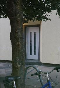Una bicicleta estacionada al lado de un árbol al lado de una puerta. en Down-Town-Oasis, en Düsseldorf