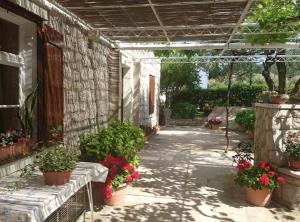 a patio with potted plants and a building at Apartment Ana Broce in Broce