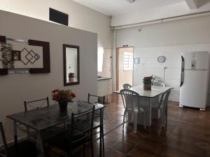 a kitchen and dining room with a table and a refrigerator at Hospedagem Recanto Miriam -Salto in Salto