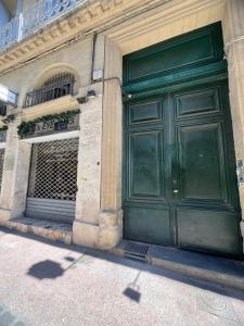 una porta verde sul lato di un edificio di LA SUITE - Appartement Centre Historique a Montpellier