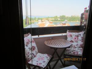 a balcony with two chairs and a table and a window at Guesthouse Olimp in Sozopol