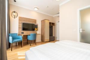 Łóżko lub łóżka w pokoju w obiekcie Das Jedermann Boutiquehotel mit Stadtgarten