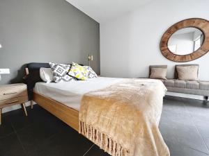 Un dormitorio con una cama con espejo y un sofá. en Apartment Sleeps 4 with Scenic Views, en Villaverde