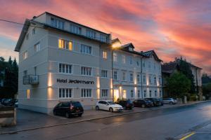 duży biały budynek z zaparkowanymi przed nim samochodami w obiekcie Das Jedermann Boutiquehotel mit Stadtgarten w mieście Salzburg