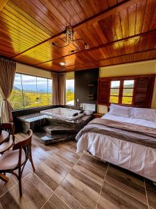 a bedroom with a large bed and a bath tub at Pousada Via Láctea in Três Cachoeiras
