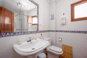 a bathroom with a sink and a toilet and a mirror at Casa Lucero Ronda in Ronda +16 photos