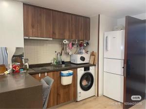 een keuken met een wasmachine en een koelkast bij Luxury Entire 1B flat in ChangNing in Shanghai