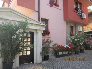 a building with potted plants and flowers in front of it at Guesthouse Olimp in Sozopol