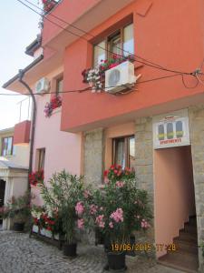 a pink building with flowers in front of it at Guesthouse Olimp in Sozopol