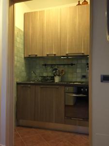 a kitchen with wooden cabinets and a stove top oven at Appartamento Arnolucci in Rovere