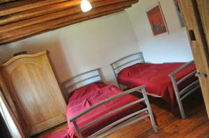 um quarto com 2 camas e um cobertor vermelho em Oneux em Oneux