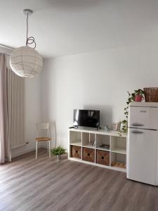a living room with a white refrigerator and a table at Casa Maino in Rho
