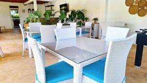 Una mesa y sillas blancas en un comedor. en Minah Bungalows, en Nungwi