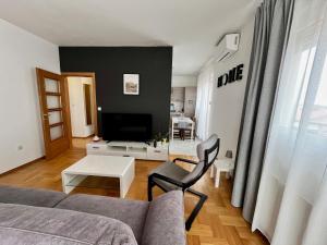 a living room with a couch and a tv at Apartment Aurora in Buzin