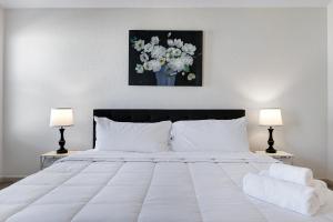 une chambre avec un grand lit blanc avec deux lampes dans l'établissement Retro - A Birdy Vacation Rental, à Von Ormy