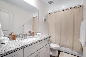 une salle de bain avec un lavabo, des toilettes et un miroir dans l'établissement Retro - A Birdy Vacation Rental, à Von Ormy 30 autres photos