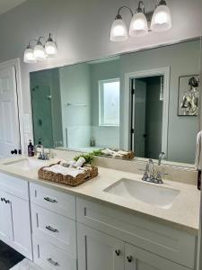a bathroom with two sinks and a large mirror at Luxe Oasis in the heart of Houston! in Houston