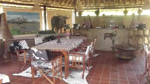 a dining room with a table and some animals on the wall at Buffalo's Rest Greenpark-Naivasha in Naivasha