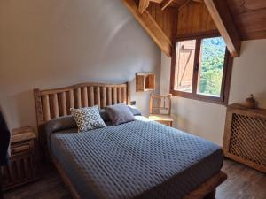 Un dormitorio con una cama con edredón azul y una ventana. en Alojamientos Ruraltena, en Piedrafita de Jaca 75 fotos más