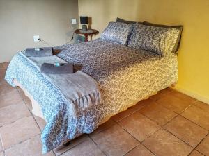 a bedroom with a bed with a blanket on it at 83 on De Lange in Graskop