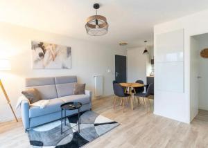 モンテヴランにあるAppartement Cosy Disneylandの青いソファとテーブルのあるリビングルーム