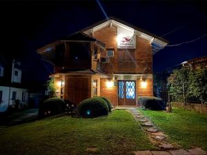 a brick house with a sign on it at night at Pousada dos Pássaros in Gramado