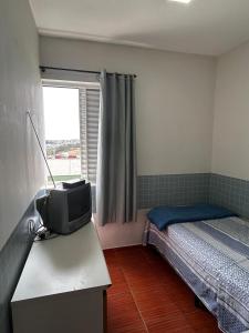 a bedroom with a bed and a tv on a table at Hospedagem Recanto Miriam -Salto in Salto