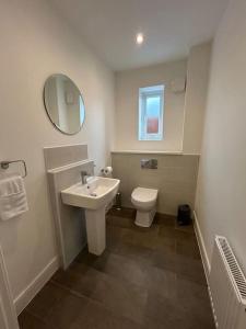 a bathroom with a sink and a toilet and a mirror at Nice house close to the city centre and stadium in Manchester