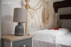 フェラーラにあるSTUDIO LOFT FERRARA centro storico vista castelloのベッドと「愛」という言葉が書かれたランプのある寝室