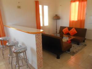 a living room with a couch and a bar at Ô PARADIS TERRESTRE Gîte passion in Capesterre
