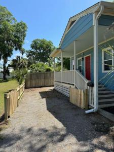 una casa azul con un porche y una puerta roja en 5Min Walk to Waterfront. Pet Yes, en Beaufort