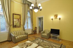 a living room with two chairs and a flat screen tv at Charming Art Deco Flat in Budapest