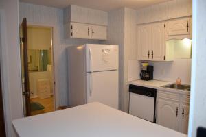 una cucina con mobili bianchi e un frigorifero bianco di 5 Vaqueria Lane a Hot Springs Village Altre 14 foto