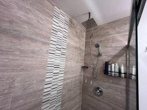 a bathroom with a shower with a glass door at Pet Friendly Sleeps 9 HighSpeed WiFi 500MBPS Plus in Fresno +25 photos