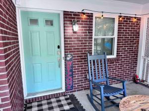 a blue door on a brick house with a blue chair at Quality Stay Location. Pet Yes in Beaufort