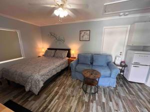 a bedroom with a bed and a blue couch at Cozy Studio Retreat. Pet Yes in Beaufort