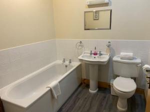 a bathroom with a tub and a toilet and a sink at Dalfaber House Luxury holidays in the Highlands in Aviemore +27 photos
